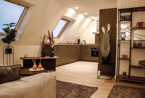a living room with a couch and a kitchen at Appartement 3 haasjes in landelijke omgeving in Wijdenes