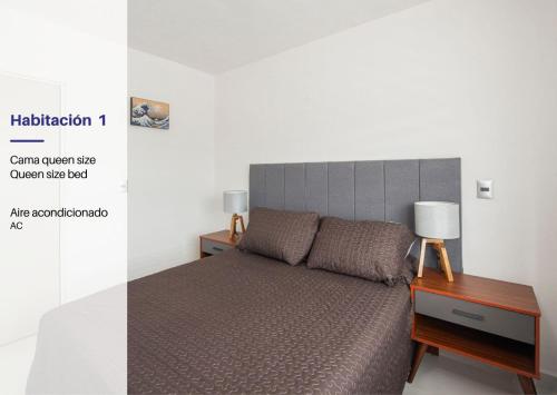 a bedroom with a bed with a headboard and a table at Cozy 2-Bedroom Retreat with Pool Access in Manzanillo