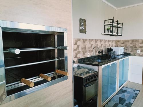 a kitchen with a black oven and a sink at Para Família - privacidade e lazer próximo ao lago de Itaipu in Foz do Iguaçu