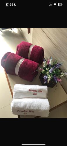 a pile of towels and flowers on a table with towels at Eco Paradise Cumbuco 128 in Cumbuco