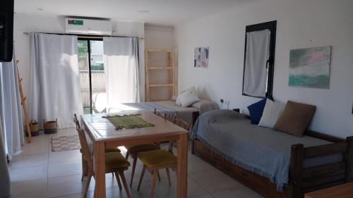 チャパドマラルにあるLa Surfina en Chapadmalalのベッドとテーブルとソファのある寝室