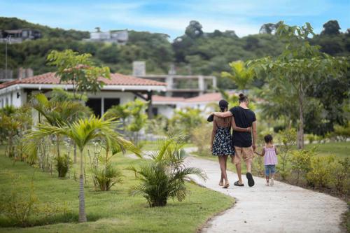 a man and woman walking down a path with a child at Charming & Spacious 2BR Condo E22 at Playa Venao in Playa Venao