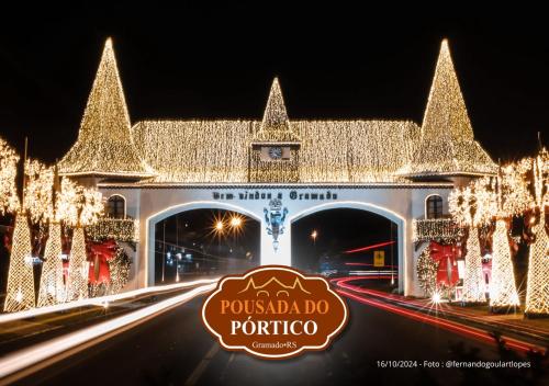 a building covered in christmas lights with a sign in front at Pousada do Pórtico in Gramado