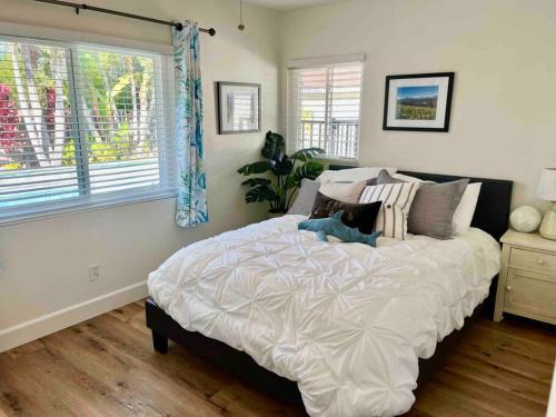 科斯塔梅萨Oasis OC Pool l Spa 8 min 2 Beach的卧室配有带枕头的大型白色床