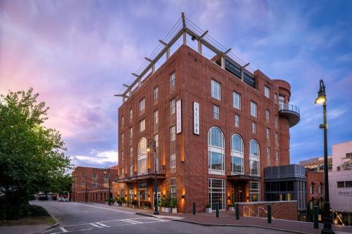 a large red brick building on a city street at The Alida, Savannah, a Tribute Portfolio Hotel in Savannah