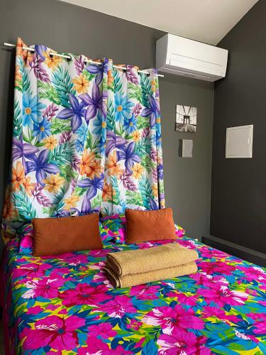 a bed with a flower patterned headboard in a room at Keamana Lodge 1 in Bora Bora