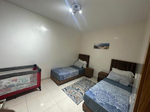 a bedroom with two beds and a ceiling at Apartment am Meer mit Pool in Aourir