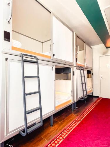 a room with white bunk beds and a red rug at Copenhagen Downtown Hostel in Copenhagen