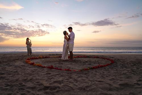 a couple standing in a heart on the beach at Norte Suites Boutique in Los Órganos