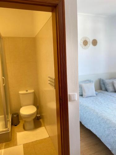 a bathroom with a toilet and a bed in it at House near Ribeira with Garden, Terrace & Yoga Studio in Santo Isidoro