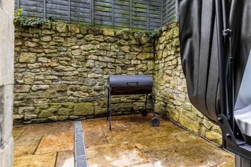 a stage with a chair in front of a stone wall at Locksbrook Lodge - Hot Tub - Spacious Outdoor Space in Bath
