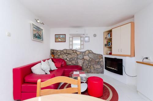 a living room with a red couch and a fireplace at House Ana in Kornić