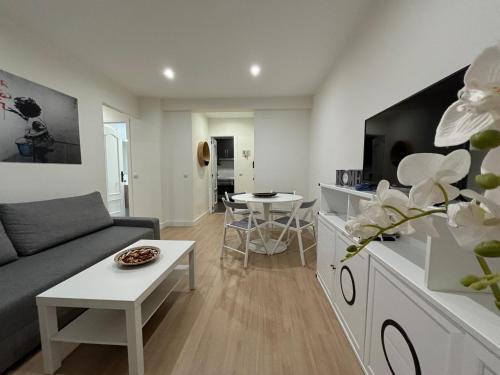 a living room with a couch and a table at Espacioso Apartamento Familiar con terraza en Aranjuez - Confort, Tranquilidad y Netflix Incluido in Aranjuez