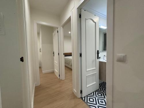 a hallway with a door leading to a bedroom at Espacioso Apartamento Familiar con terraza en Aranjuez - Confort, Tranquilidad y Netflix Incluido in Aranjuez