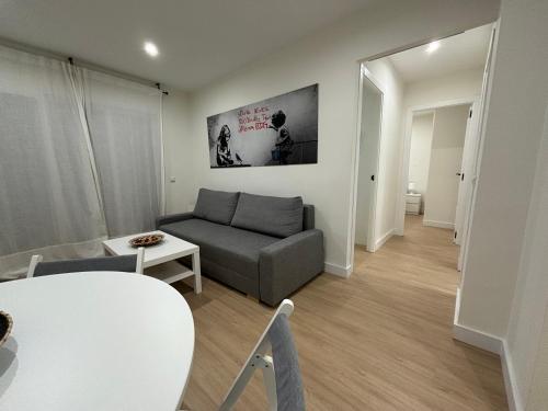 a living room with a couch and a table at Espacioso Apartamento Familiar con terraza en Aranjuez - Confort, Tranquilidad y Netflix Incluido in Aranjuez
