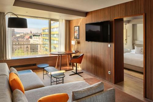 a hotel room with a couch and a tv at Budapest Marriott Hotel in Budapest