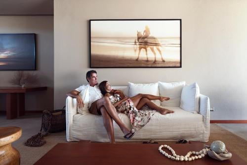 a man and a woman sitting on a couch at Norte Suites Boutique in Los Órganos
