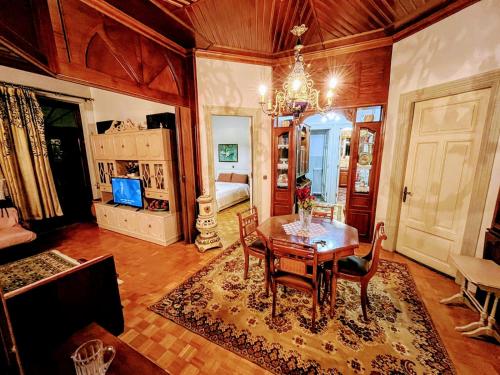 a dining room with a table and chairs and a bedroom at Κομψό & πολυτελές νεοκλασικό στο κέντρο της πόλης in Kastoria