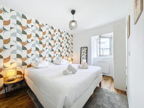 - une chambre avec un lit blanc et un mur géométrique dans l'établissement Ty Podic, à Brest