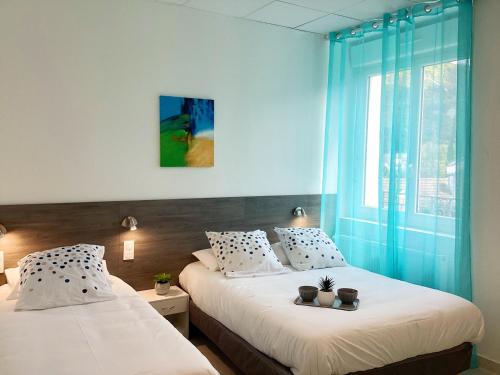 deux lits jumeaux dans une chambre avec fenêtre dans l'établissement Appartement Stella 95 m2 climatisé parking proche Sanctuaires, à Lourdes