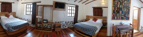 a room with two beds and a tv in it at Tika bungalows hotel in Ollantaytambo