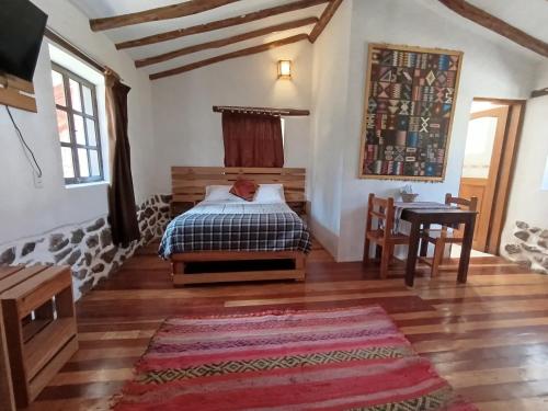 a bedroom with a bed and a desk in a room at Tika bungalows hotel in Ollantaytambo