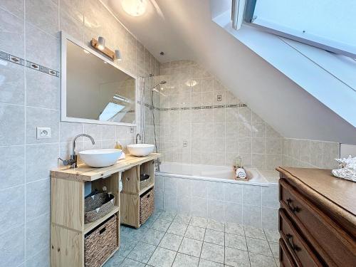 une salle de bain avec deux lavabos et une baignoire dans l'établissement Lagadenn jolie maison T4 terrasse jardin clos, à Plozévet
