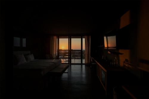 a dark room with a bed and a view of the ocean at Norte Suites Boutique in Los Órganos