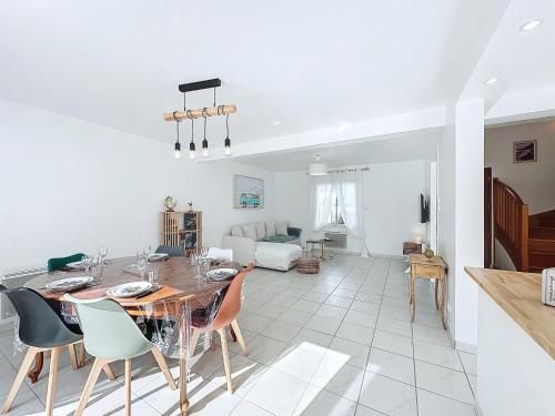 une salle à manger et un salon avec une table et des chaises dans l'établissement Lagadenn jolie maison T4 terrasse jardin clos, à Plozévet