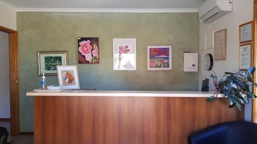 a reception counter with pictures on the wall at The Finley Palm Motor Inn in Finley