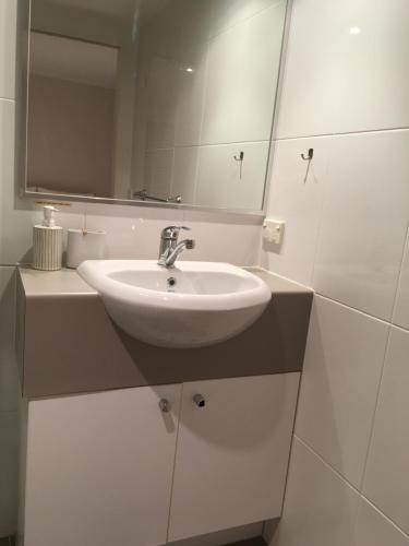 a bathroom with a sink and a mirror at Merivale stay in South Brisbane two beds two baths one parking in Brisbane