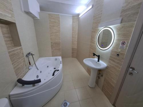 a bathroom with a bath tub and a sink at Z&G Apartment in Bitola