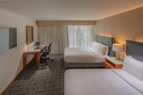 a hotel room with two beds and a desk at Presidente InterContinental Puebla by IHG in Puebla