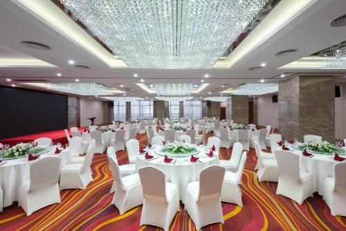 a conference room with white tables and chairs and a screen at Holiday Inn Shanghai Vista by IHG - Easy access to travel spot city walk in Shanghai