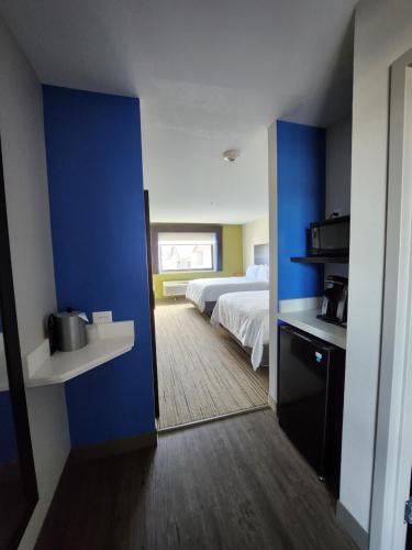 a room with a bed and a blue wall at Holiday Inn Express & Suites - Camas by IHG in Camas