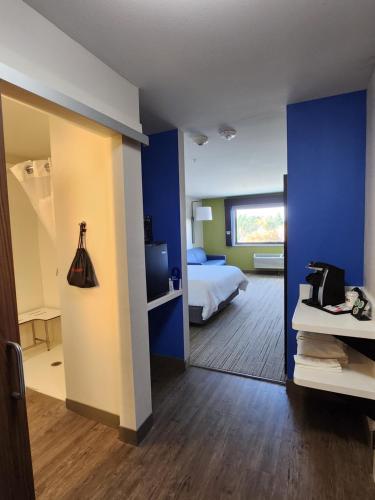 a room with a bed and a room with blue walls at Holiday Inn Express & Suites - Camas by IHG in Camas