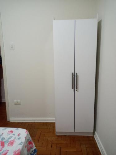 a white cabinet in a room next to a bed at Pousada Catarina - 2 in Maringá