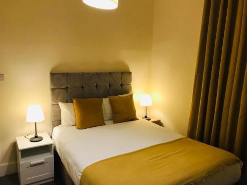 a bedroom with a large bed with two lamps at Vauxhall Stay in London