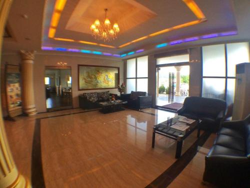 a large living room with a chandelier and a living room with a table at Grand Hoyah Hotel in Olongapo
