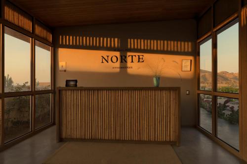 a lobby with a nordic sign on the wall at Norte Suites Boutique in Los Órganos