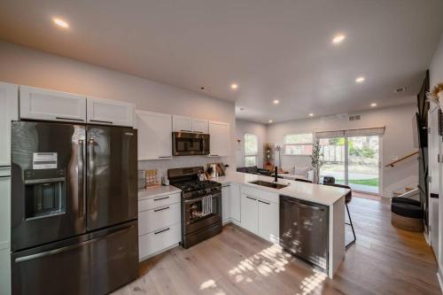 a kitchen with stainless steel appliances and white cabinets at Hot Tub Amazing Location! Modern Ohio City Luxury 2 King Beds in Ohio City