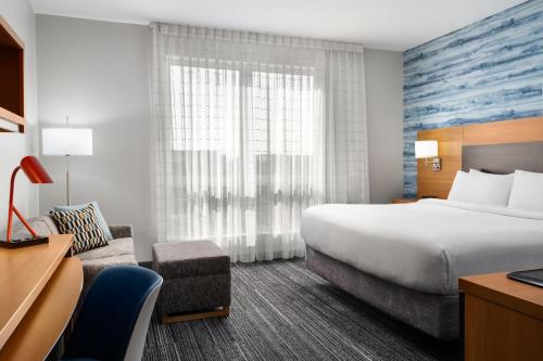a hotel room with a bed and a desk at TownePlace Suites by Marriott Champaign in Champaign