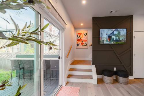 a staircase in a house with a tv on the wall at Hot Tub Amazing Location! Modern Ohio City Luxury 2 King Beds in Ohio City