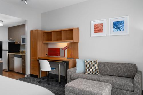 a living room with a couch and a table and a kitchen at TownePlace Suites by Marriott Champaign in Champaign