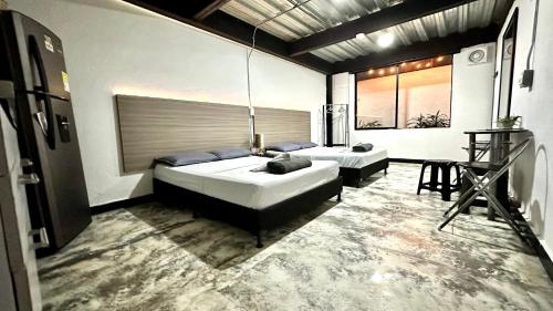 a bedroom with two beds and a table in it at Jardin Loft in Medellín