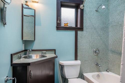 a bathroom with a toilet and a sink and a mirror at Cozy Capitol Hill Cottage in Seattle