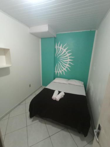 a small room with a bed and a wall with a drawing at Hospedagem 4Lm in Penha