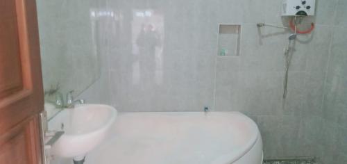 a bathroom with a white toilet and a sink at The Bunut Villas in Kubupenlokan