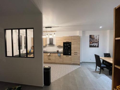 une cuisine et une salle à manger avec une table et un comptoir dans l'établissement Grande maison équipée, à Villejuif