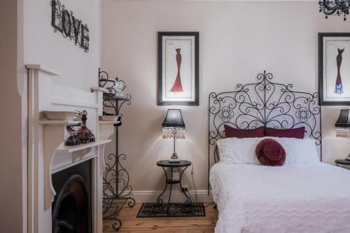 a bedroom with a white bed and a fireplace at Azalea Cedar-Rose Barossa Valley Villa in Lyndoch